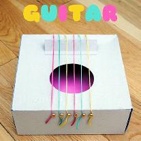 Гитара из картонной коробки с разноцветными струнами